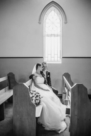 The bride and groom sitting in the church pews