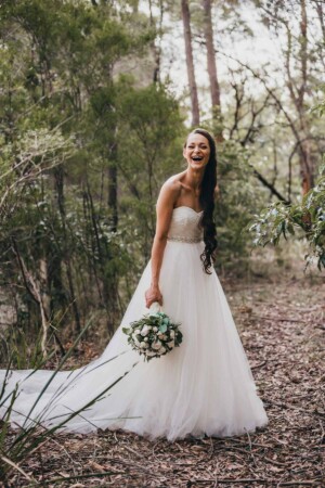 A bride laughing in the bushland at Chapel Hill