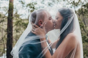 A bride and groom kissing under her veil