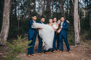 The groom and groomsmen lift the bride up