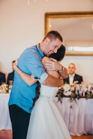 A bride embraces her brother at the reception