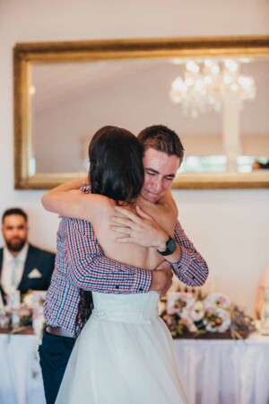Brides brother cries while hugging his sister