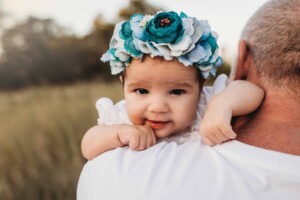 A baby girl is held on her daddy's shoulder