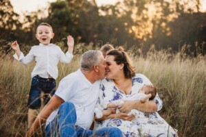 Parents steal a kiss while their kids giggle and woop