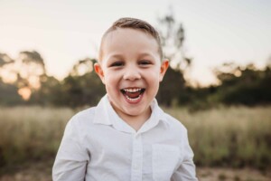 A little boy cheekily grinning at the camera