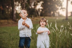 A brother and sister standing in long grass
