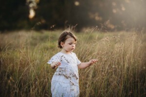 A little girl carefully walking through long grass