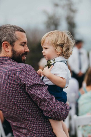 The page boy cuddling dad at the wedding
