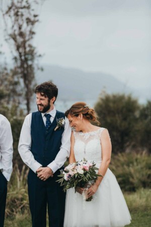 A bride nuzzles her groom during the ceremony