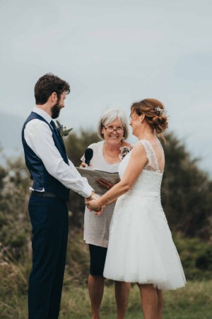 A couple hold hands as they exchange wedding vows