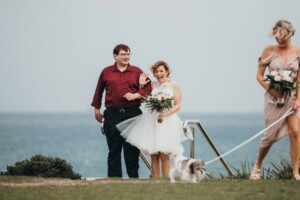 Bride waves to wedding guests at Sandon Point
