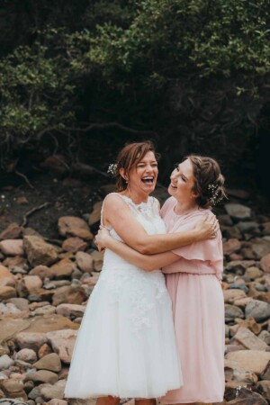 The bride and her bridesmaid share a joke