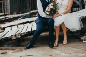 Newlyweds holding hands at Sandon Point boat sheds