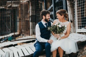 Bride & Groom sitting at Sandon Point boat sheds