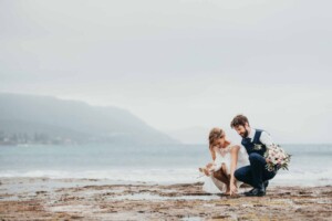A couple explore the rock pools after their wedding