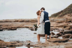 A married couple kiss at their Sandon Point wedding