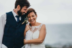 A bride snuggles into her groom's arm