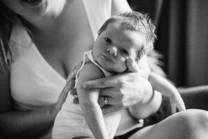 A mother settles her newborn after a feed
