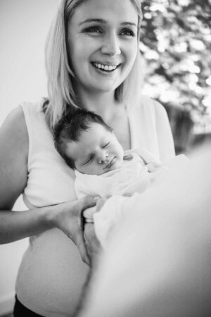 A happy mother holds her baby boy