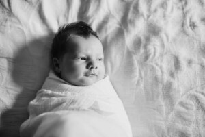 A newborn baby boy looking out the window