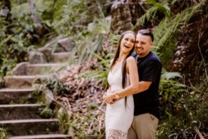 An engaged couple embrace and share a candid giggle