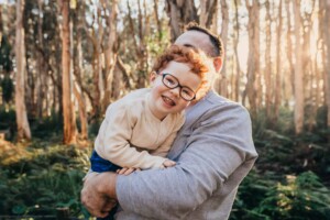 A smiley little boy stares into the camera lens fascinated