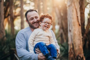 A father and son laugh together during the family photo shoot