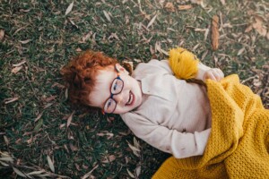 A little boy plays under a blanket in a Sydney park photo shoot