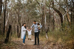 Family with 2 little boys playing on a bush track