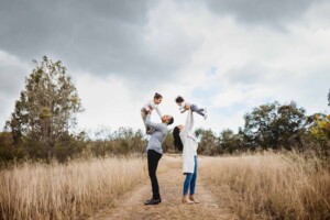 A family swing their boys above them as they play aeroplane games