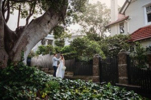 A groom gently strokes his bride's cheek after the wedding
