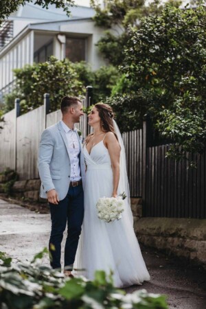 A bride and groom embrace on a path after their wedding