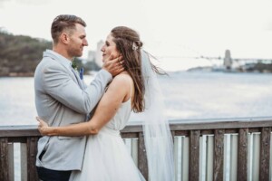 A groom gently cups his brides face in his hands as they gaze at each other
