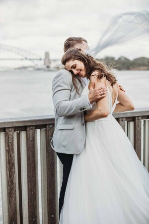A groom gently holds his bride as she rests on his shoulder