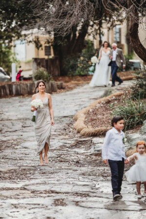 A bridesmaid walks down the path leading to the wedding ceremony