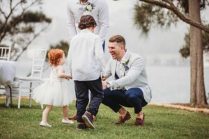 A groom greets his ring bearer and flower girl before the wedding