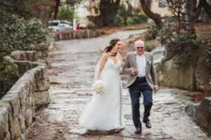 A bride walks towards the wedding ceremony with her father