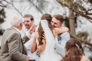 A bride hugs her groom as their wedding ceremony begins