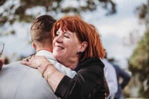A guest hugs the groom before the wedding ceremony at Birchgrove