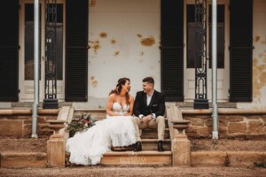 Gledswood Wedding - A bride and groom sit on the steps of the homestead