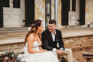 Gledswood Wedding - A bride and groom sit together on the steps of Gledswood homestead
