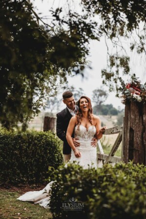 Gledswood Wedding - Bride and groom standing against a rustic gate at Gledswood Estate