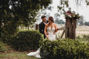 Gledswood Wedding - Bride and groom standing against a rustic gate at Gledswood Estate