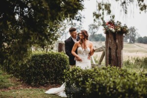 Gledswood Wedding - Bride and groom standing against a rustic gate at Gledswood Estate