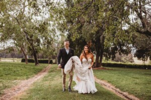 Gledswood Wedding - Bride and groom walk along the treelined driveway at Gledswood Estate