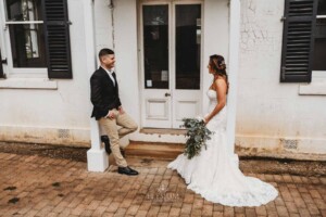 Gledswood Wedding - Married couple stand at a rustic door of the music room at Gledswood