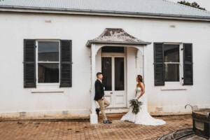 Gledswood Wedding - newlyweds stand at a rustic door of the music room at Gledswood