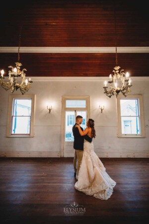 Gledswood Wedding - A groom holds his bride close as they practice their first dance in the Gledswood Homestead music room