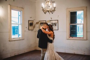 Gledswood Wedding - A groom holds his bride close as they practice their first dance in the Gledswood Homestead music room