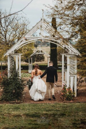Gledswood Wedding - bride and groom stroll through the homestead gardens